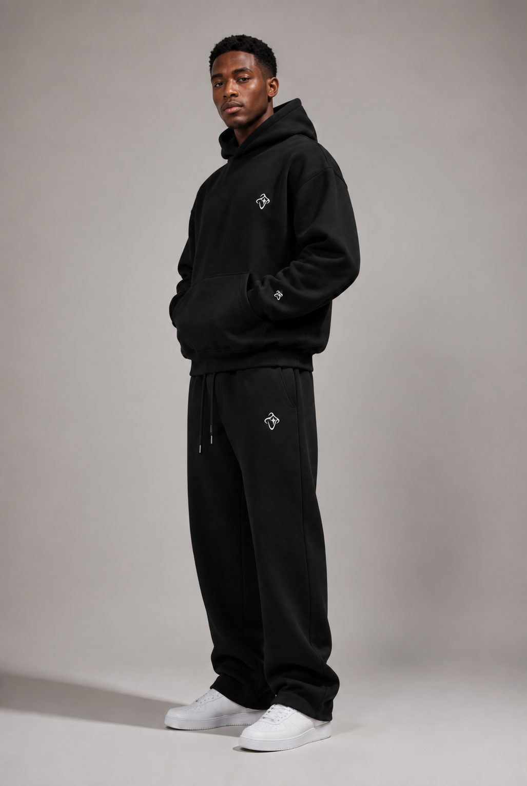 Model trägt den schwarzen Hoodie und die Jogginghose aus Drop 01